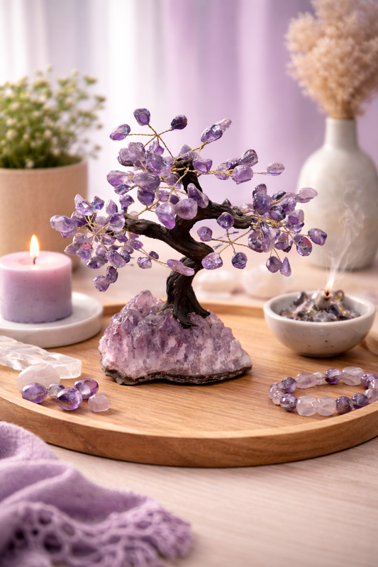 Decorative setting with amethyst tree, candle, and crystals on a wooden board.