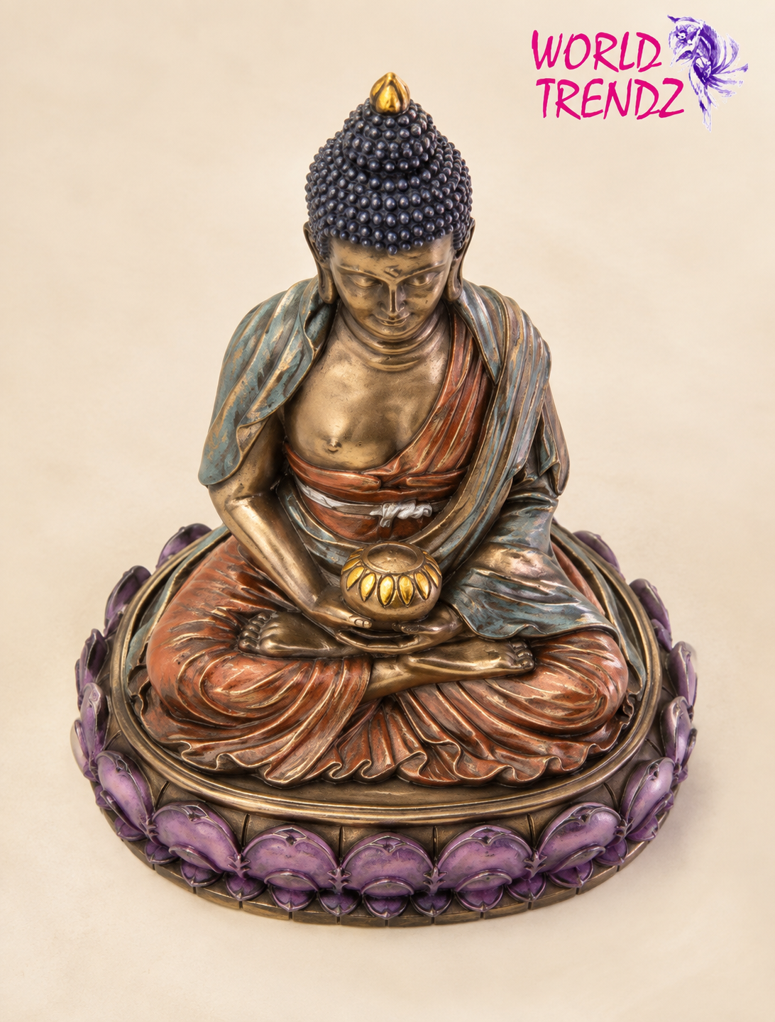 A seated Buddha Double Lotus Amitabha figurine with a bronze-toned finish, blue-gray drapery, and a purple lotus base, photographed against a plain beige background. A pink 'WORLD TRENDZ' logo appears in the top right corner.