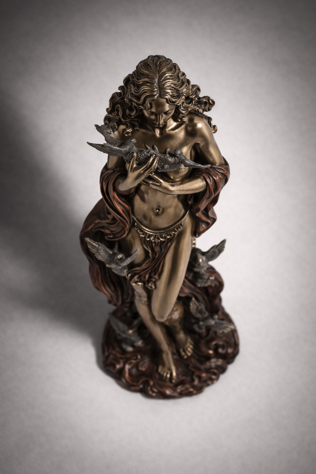 Bronze statue of Aphrodite holding a sword on a gray background