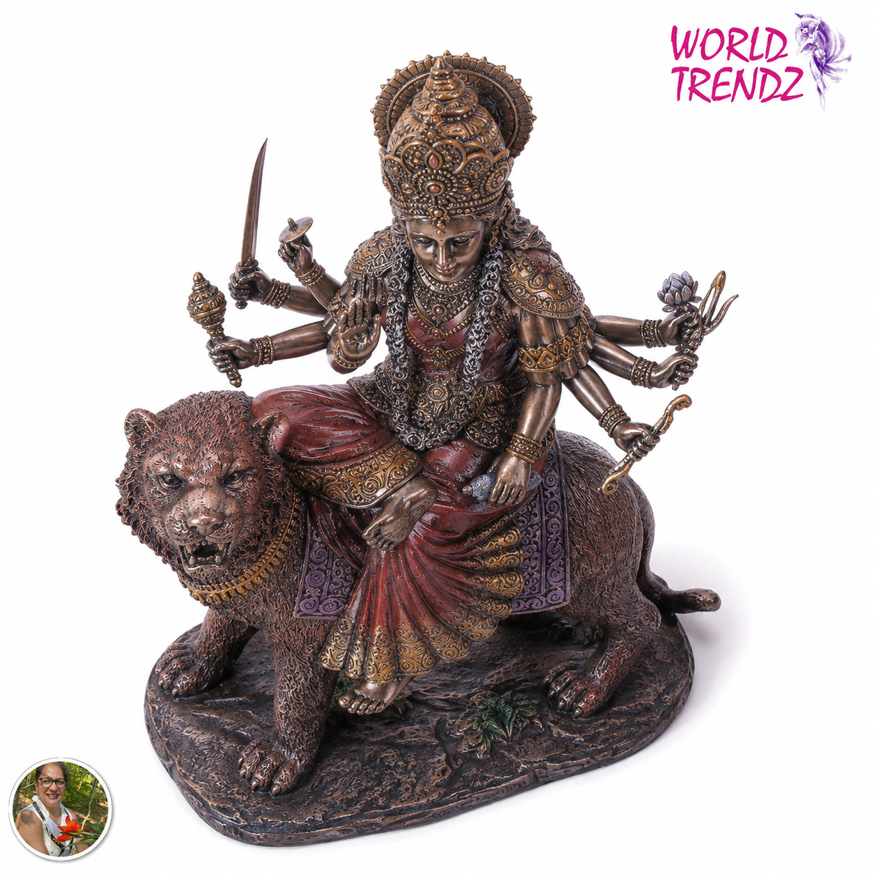 A detailed statue of a multi-armed female deity Durga riding a lion, shown on a plain white background. The statue has a metallic bronze finish with red and gold painted drapery accents.