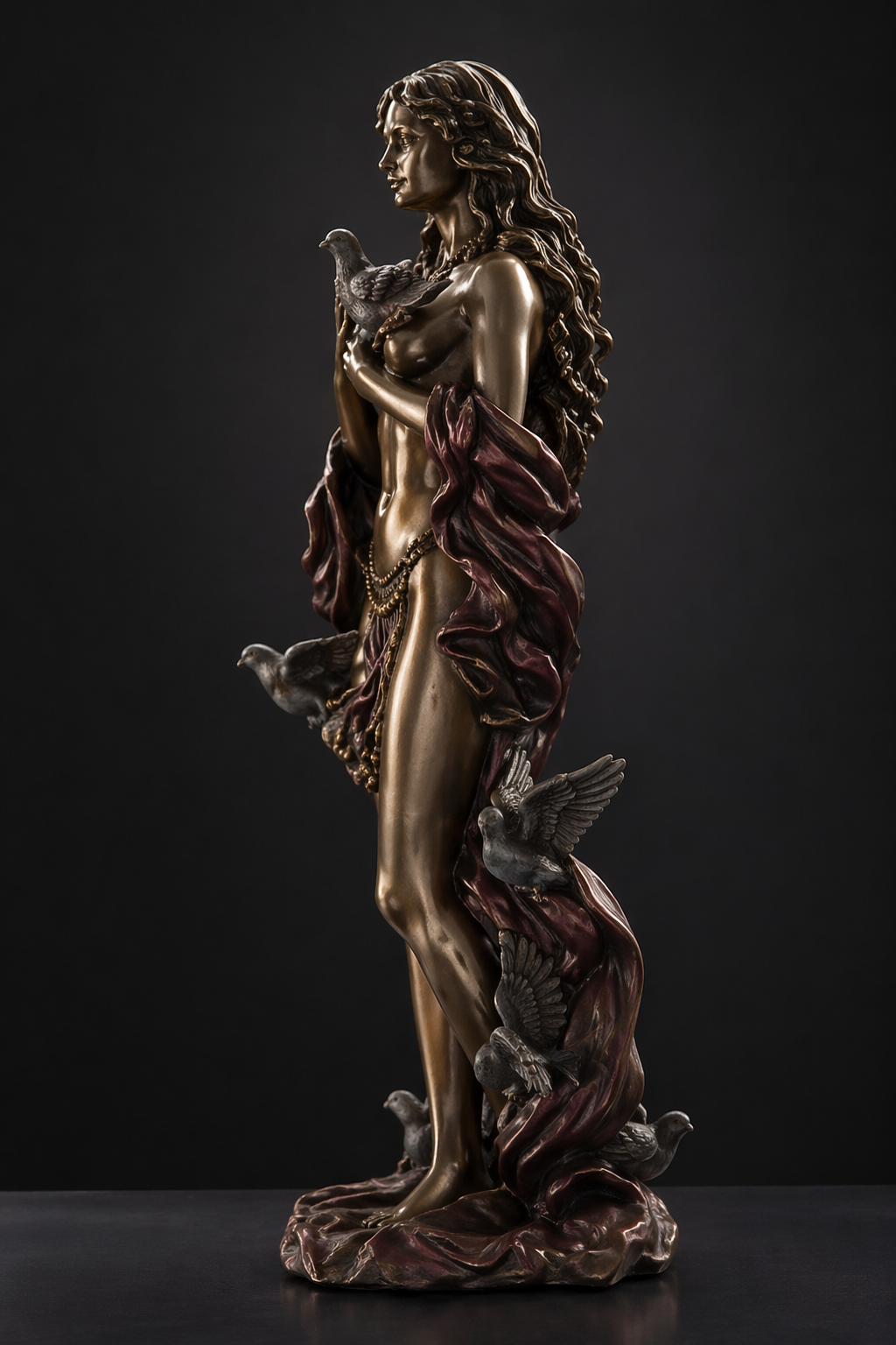 Bronze statue of Aphrodite with doves on a dark background