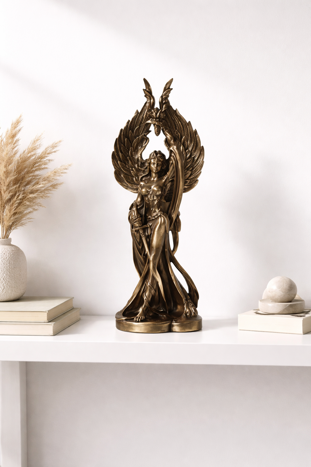 Bronze Goddess Morrigan statue on a white shelf with decorative items