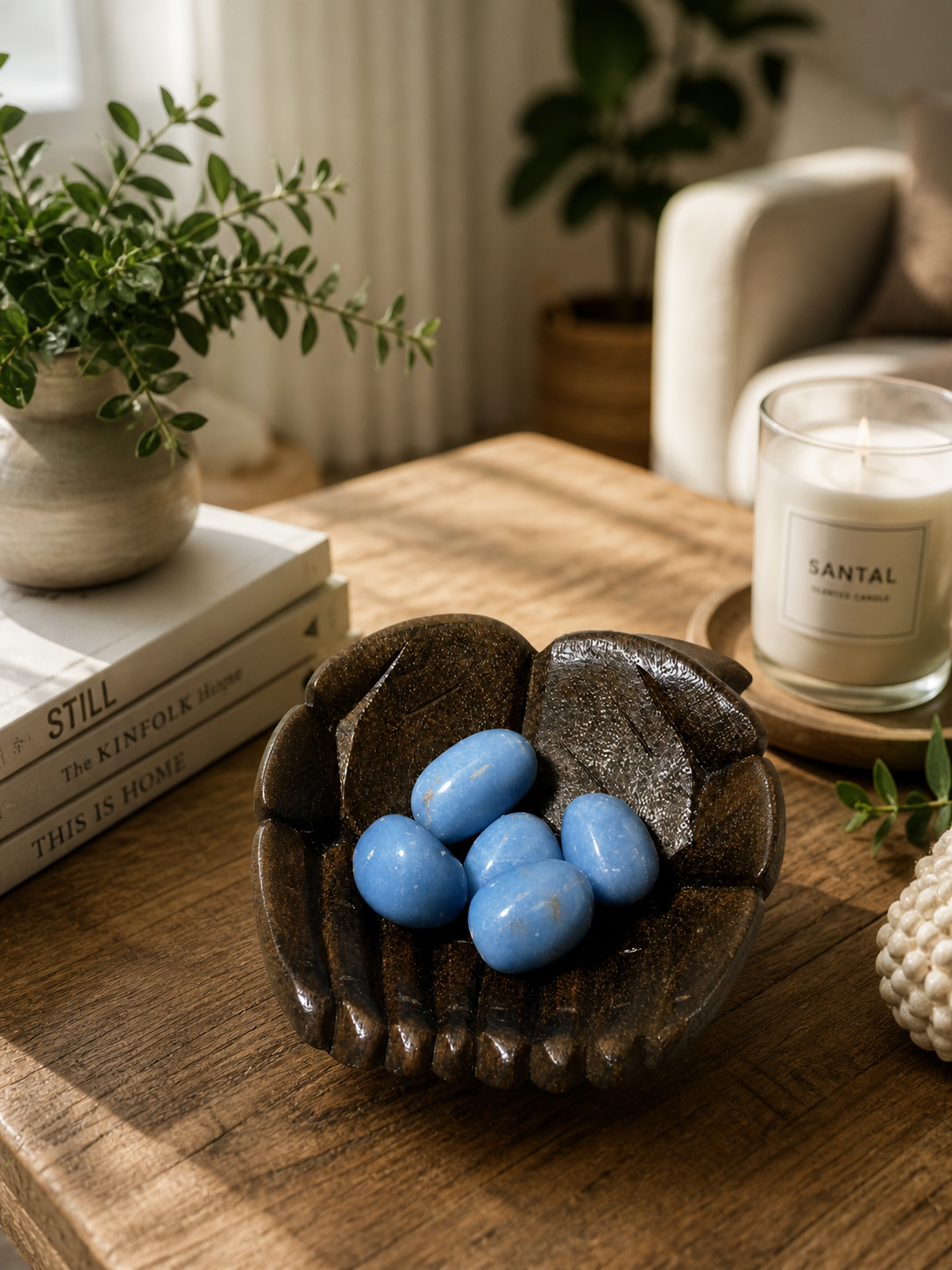 The Angelite gemstone styled as a home décor element. Natural daylight, soft shadows, and a cozy interior feel suggest the stones are used to enhance the aesthetic and energy of a living space. Emphasis on warmth, grounding, and visual harmony.