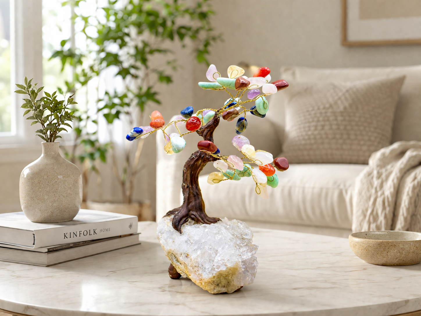 The chakra gemstone tree as a centerpiece on a modern living room table with soft natural light from a nearby window, neutral-toned furniture, and minimal décor. 