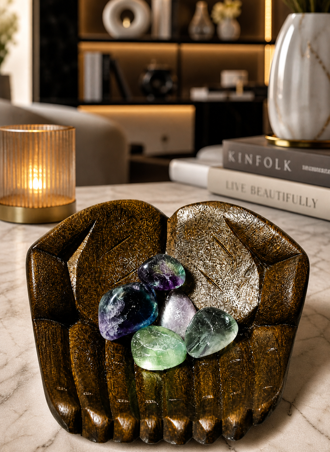 Wooden hand bowl with Fluorite stones as a décor piece on a modern marble tabletop.
