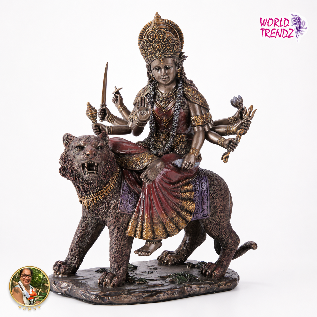 A detailed bronze-finished statue of the Hindu goddess Durga riding a tiger, set against a plain white background. The statue features intricate gold and red painted details on the drapery and ornaments.