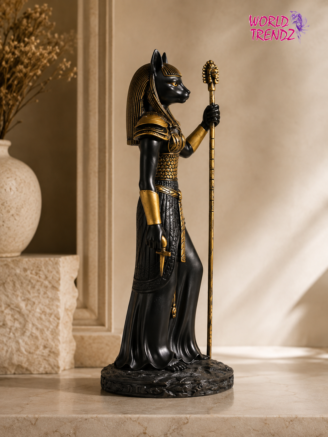 An Egyptian Bastet Goddess Statue, depicted as a black cat with gold details, holding a gold scepter, standing on a stone ledge in a warm, sunlit interior setting.