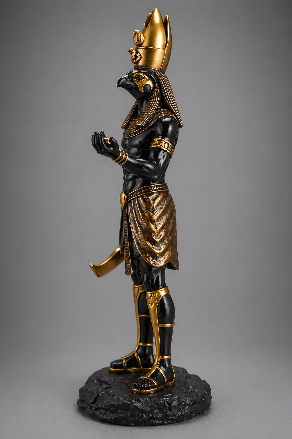 Statue of Horus with a gold headdress and black body on a gray background