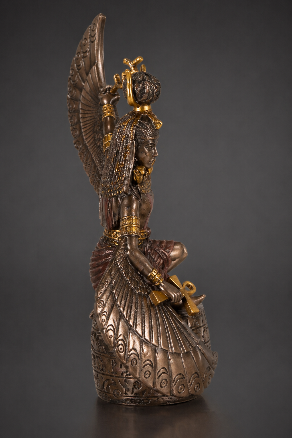 Bronze statue of Mother Isis with a sword on a dark background