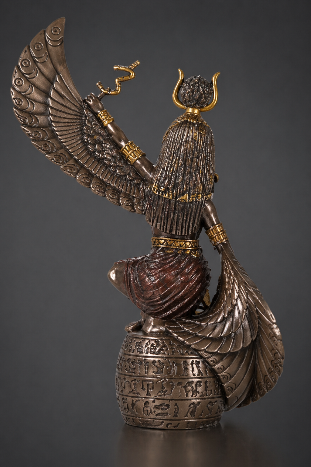Decorative statue of Mother Isis with intricate details on a dark background