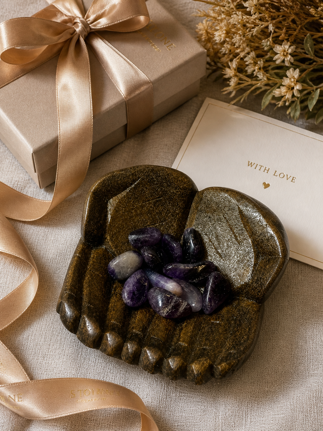 A gifting scenario with elegant wrapping elements. The carved bowl with ametrine stones is placed on a textured fabric surface, surrounded by a neatly wrapped gift box, ribbon, and a greeting card. Bright but soft lighting enhances the richness of the materials, creating a premium gifting aesthetic.