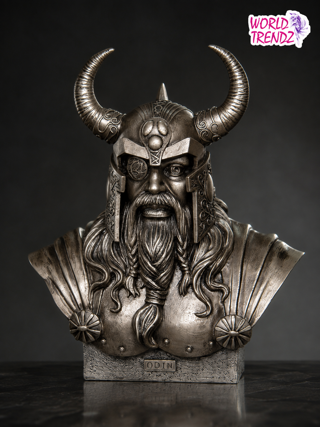 A detailed metallic silver bust sculpture of Odin, a Norse god, wearing a horned helmet and long beard, mounted on a stone-textured base. The 'WORLD TRENDZ' logo is visible in the top right corner.