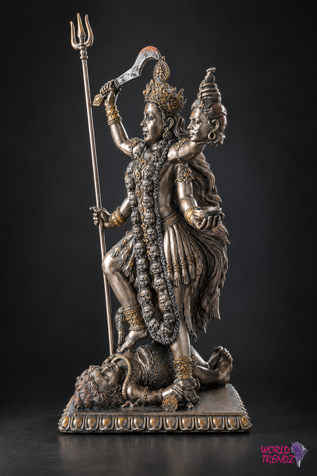 A detailed metallic statue of Lord Shiva and Goddess Kala Kali on a dark studio background, with a small 'World of Trendz' logo in the bottom right corner.