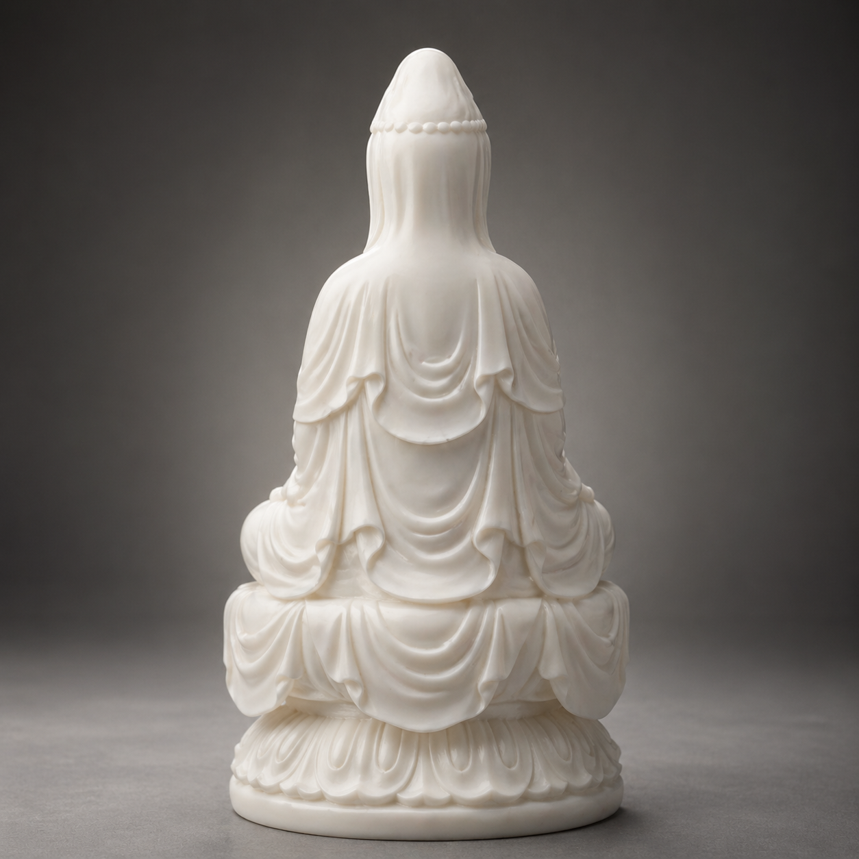 White marble statue of Kuanyin on a gray background