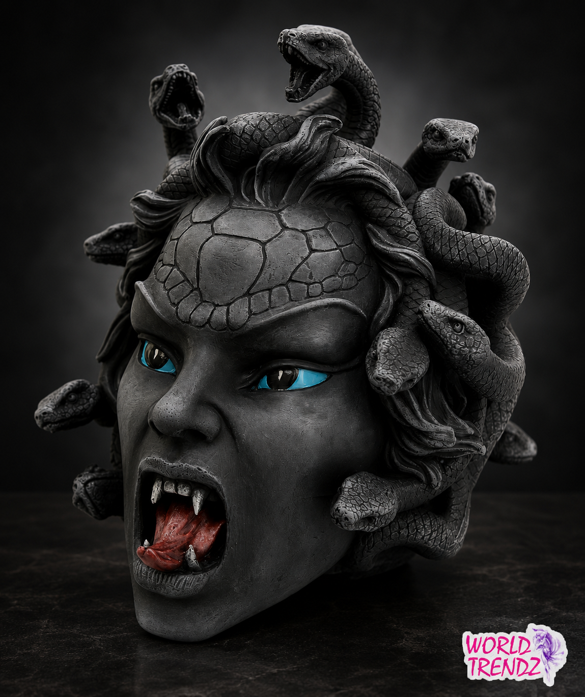 A dark gray Medusa head sculpture with snakes flowing through its hair and bright blue eyes, shown against a dark studio background. A 'WORLD TRENDZ' logo is visible in the bottom right corner.