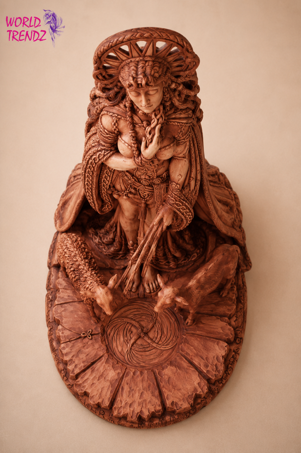 An intricately carved sculpture of Goddess Brigid, mounted on a circular base with detailed floral and geometric patterns, shown against a plain beige background.