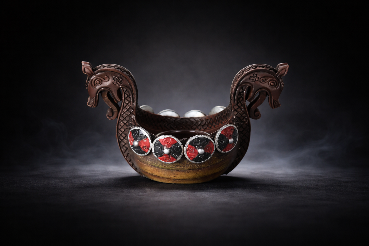Decorative object resembling a Viking longship with red and silver details on a dark background